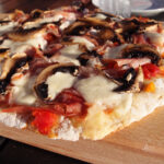 pizza, grill, gær, fuldkornshvedemel, durummel, olivenolie, tomatsauce, tomater, løg, mozzarella, ost, champignons, serranoskinke, skinke