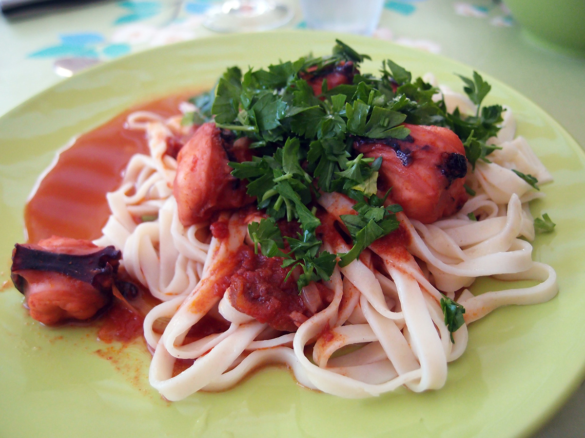 Blæksprutte i tomatsauce, rejer og pasta i fad samt fyldte courgetter